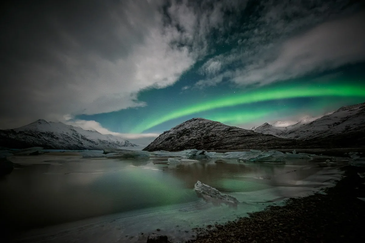 Laguna glaciale con aurora boreale, le linee curve del lago e del cielo racchiudono l'immagine ricca di elementi