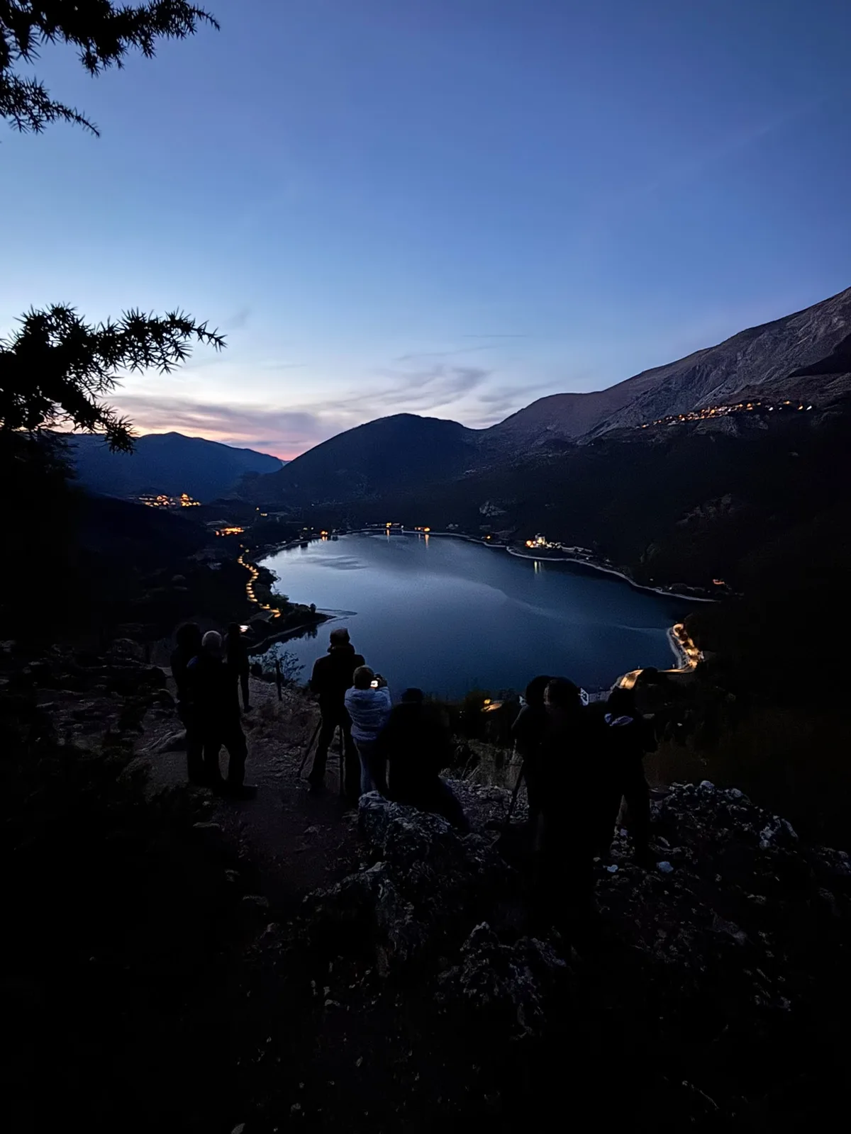 Partecipanti al workshop fotografano il Lago di Scanno all'ora blu con le luci del paese accese