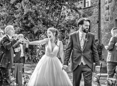 Sposi tra i confetti all'uscita della cerimonia, esempio di wedding photography insegnata nel corso online Photolab