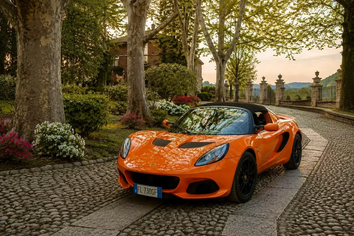 Lotus Elise arancione nel viale alberato di una villa, protagonista degli scatti del workshop di wedding photography