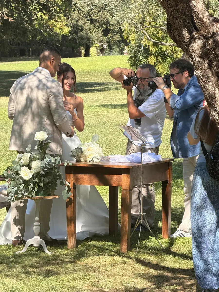Corsisti fotografano gli sposi al tavolo della cerimonia sotto gli ulivi