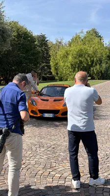 Due corsisti fotografano la Lotus Elise arancione nel viale