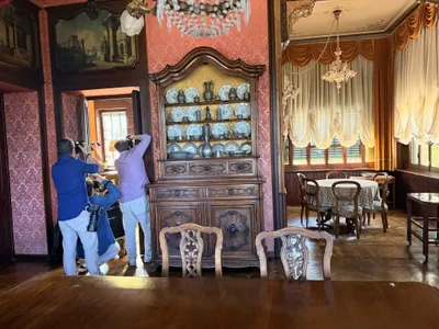 Corsisti fotografano dalla sala da pranzo con la credenza di porcellane
