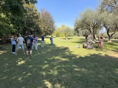 Corsisti sul prato del parco durante la cerimonia sotto gli ulivi