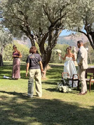 Elisabetta Rosso sistema l'abito della sposa sotto gli ulivi