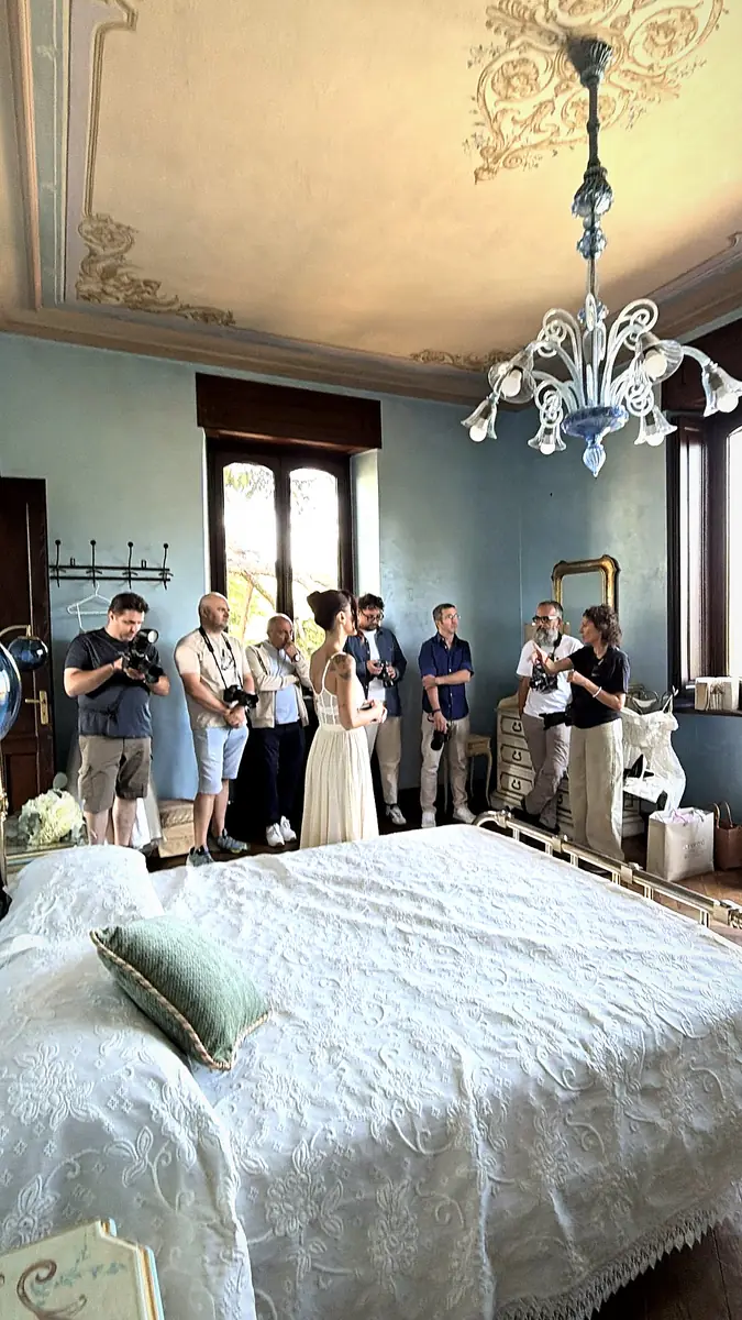 Corsisti fotografano la sposa durante i preparativi nella camera azzurra di Villa Garnerone